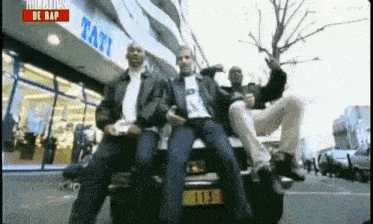 a group of men are sitting on the back of a car in front of a store that says tati